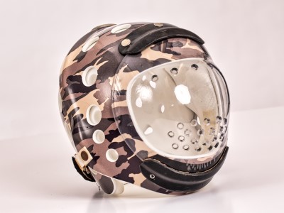 A camouflage-printed custom protective helmet sits in front of a white background.